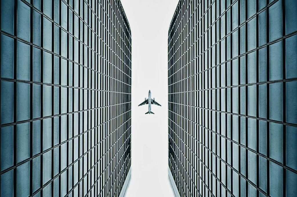 Ein Flugzeug fliegt über Bürogebäude hinweg